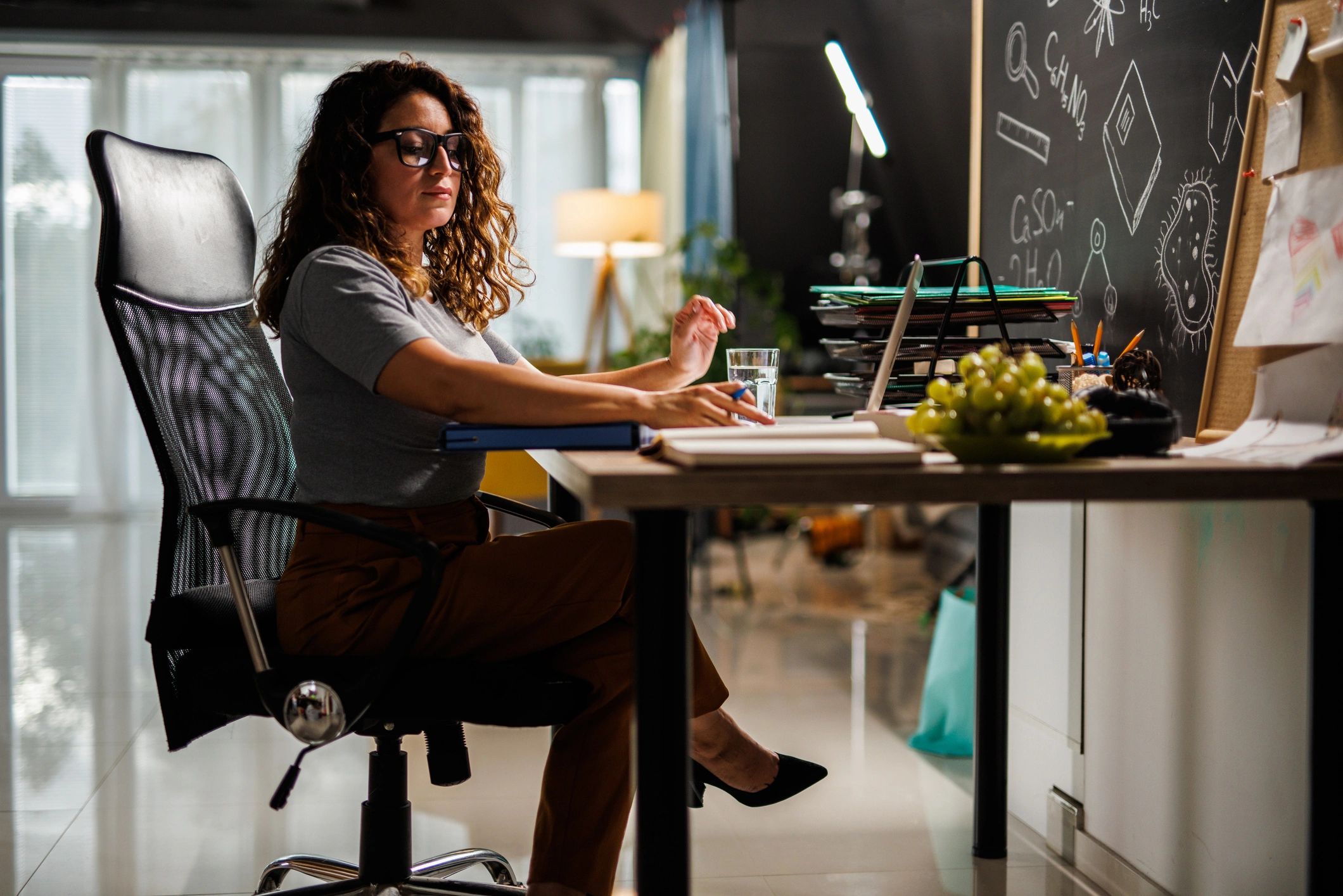 Teacher planning work at a desk with a laptop